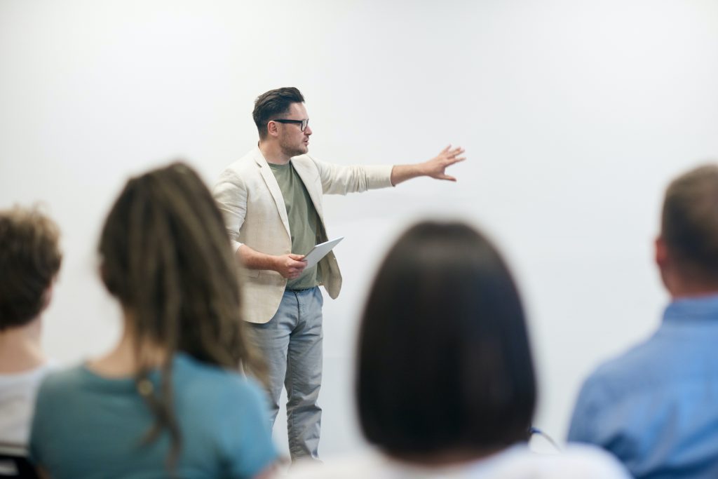 A Teacher Lecturing Class in front of Whiteboard