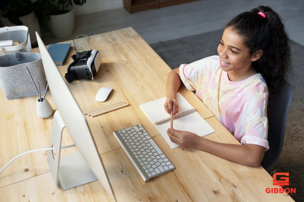 A student girl is actively taking part in the online class.